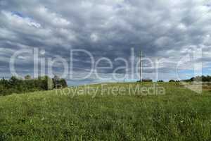 Summer landscape with green meadow and power line
