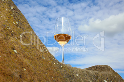 Glas mit Rosé Wein auf einem Stein