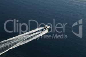 Fishing boat with motor glides on the surface of the lake