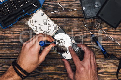 Hands with Screwdriver Disassemble HDD