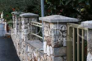 Decorative fence of stones and metal structures
