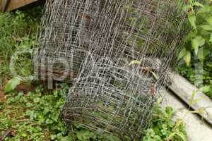 Rolls of metal mesh for fencing lie in the garden