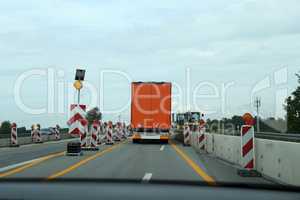 A truck drives through a construction site on the highway