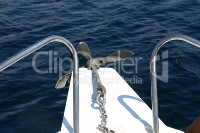 The metal anchor lies on the boat and is ready to launch