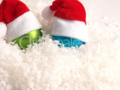 Old Christmas baubles with hat of Santa on snow