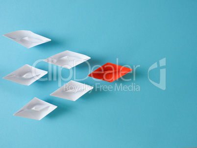 Leadership or Teamwork business concept with paper boat on a blu