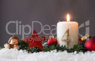 Candle of the fourth Advent burns, fir branches and Christmas tr
