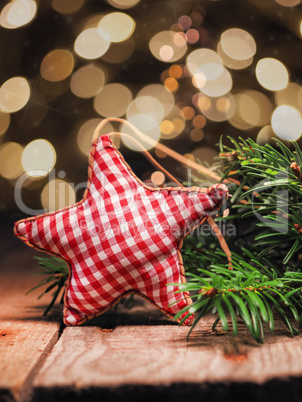 Homemade cloth star with fir branches on a wooden table in front