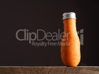 An organic carrot in the shape of a bottle with bottle cap, rust