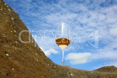Glas mit Rosé Wein auf einem Stein