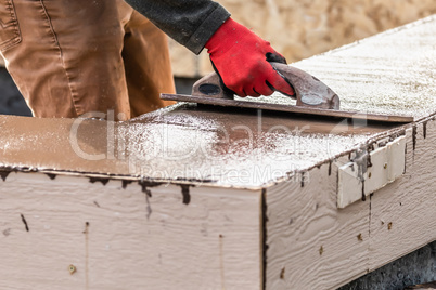 Construction Worker Using Wood Trowel On Wet Cement Forming Copi