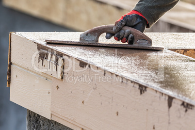 Construction Worker Using Wood Trowel On Wet Cement Forming Copi