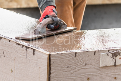 Construction Worker Using Wood Trowel On Wet Cement Forming Copi