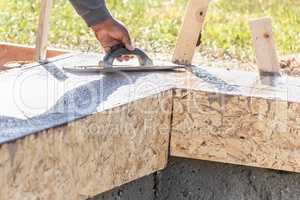 Construction Worker Using Wood Trowel On Wet Cement Forming Copi