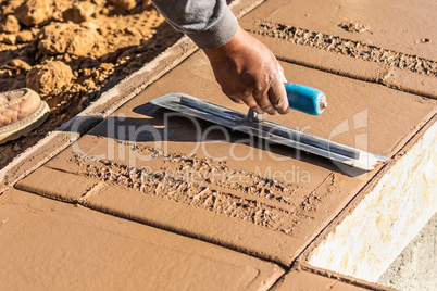 Construction Worker Using Trowel On Wet Cement Forming Coping Ar