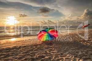 Rainbow umbrella on White sand at Delnor Wiggins State Park at s