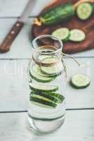 Infused water with sliced cucumber in bottle