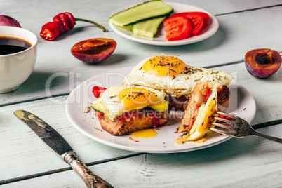 Bruschettas with vegetables and fried egg, cup of coffee and som