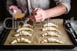 Baking sheet of raw croissants stuffed with chocolate spread