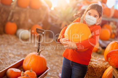 Cute Girl Choosing A Pumpkin At Pumpkin Patch Wearing Medical Fa