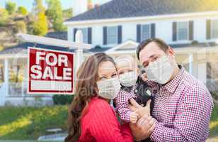 Happy Young Family Wearing Medical Face Masks In Front of New Ho