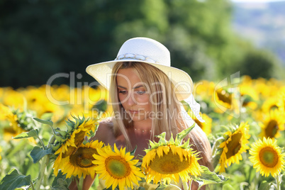 A young lady stands in a sunflower field
