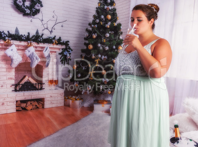 Elegante, übergewichtige Frau trinkt ein Glas Sekt.
