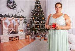 Elegante, übergewichtige Frau mit Weihnachtsgeschenk