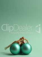 Three turquoise vintage Christmas baubles on a turquoise backgro