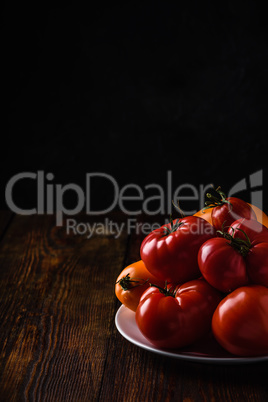 Fresh red and yellow tomatoes on plate