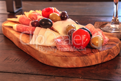Charcuterie board on rustic wood with candles behind a spread of