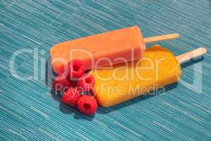 Fruit popsicles on an aqua blue background in summer