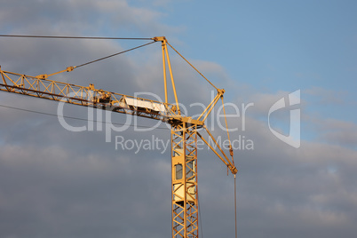 Crane at a construction site on a background of blue sky