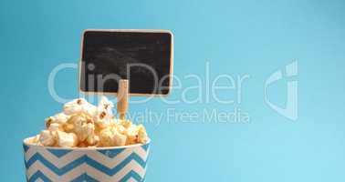 Fresh popcorn on a blue background with space for text