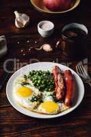 Breakfast with fried eggs, sausages and green peas