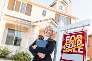 Female Real Estate Agent in Front of Sold For Sale Sign and Beau