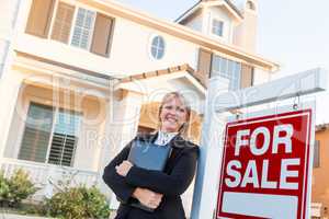 Female Real Estate Agent in Front of For Sale Sign and Beautiful