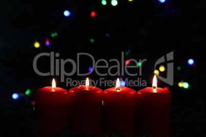 Burning red advent candles on dark background