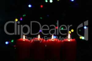 Burning red advent candles on dark background