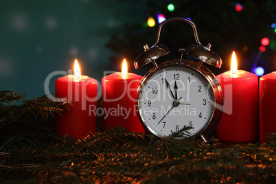 New year composition with alarm clock and burning candles