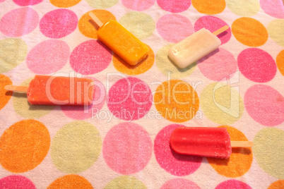Fruit popsicles on a dotted background in summer including water