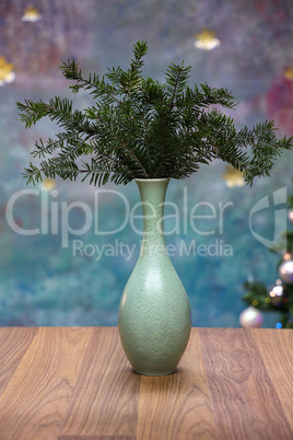 A vase with fir branches stands on the table