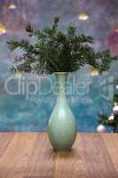 A vase with fir branches stands on the table
