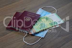 Passport with money and mouth and nose protection mask