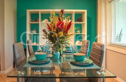 Tropical blue table set with flowers including Heliconia bihai,