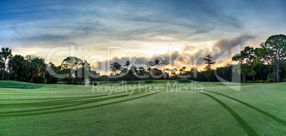 Dawn breaks over the golf cart paths along the grass of a golf c