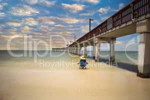 Sunset over Lone woman relaxing beside the Boardwalk of the Fort