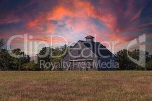 Sunset over a rustic barn in a field on Cape Cod