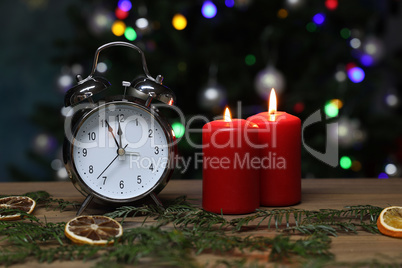 New year composition with alarm clock and burning candles