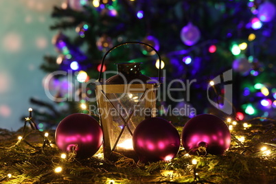 Christmas still life with bright Christmas garlands and a luminous lantern